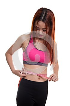 Beautiful Asian healthy girl measuring her waist.