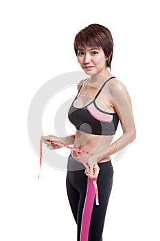 Beautiful Asian healthy girl measuring her waist.