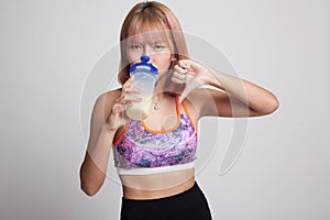 Beautiful Asian healthy girl thumbs down hate whey protein.