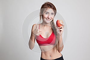 Beautiful Asian healthy girl thumbs up with apple.