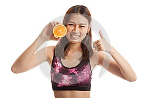 Beautiful Asian healthy girl thumbs up with orange fruit.