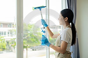 Beautiful Asian housewife doing housework and cleaning the house with an apron, using a vacuum