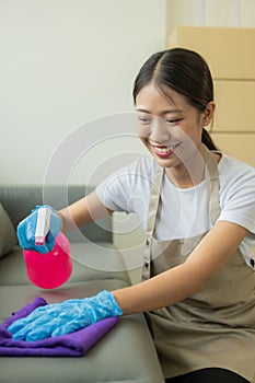 Beautiful Asian housewife doing housework and cleaning the house with an apron, using a vacuum