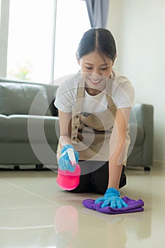 Beautiful Asian housewife doing housework and cleaning the house with an apron, using a vacuum