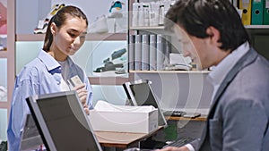 Beautiful asian lady in a shoe shop she buy some new shoes happy she giving her credit card to the seller man he using