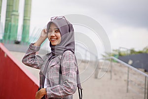 beautiful asian muslim hijab student with hands on head in park