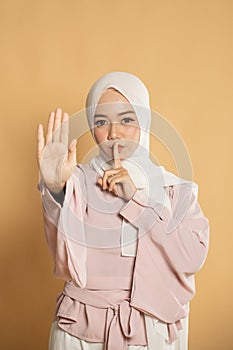 beautiful asian muslim woman showing queit gesture