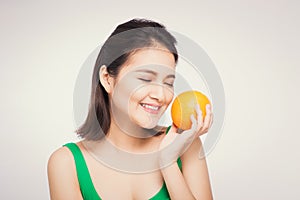 Beautiful asian portrait of young woman with oranges. Healthy food concept. Skin care and beauty. Vitamins and minerals.