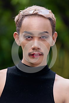 Beautiful Asian queer LGBT community supporter man with mustache wearing lipstick and jumpsuit photo