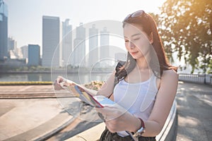 Beautiful asian solo tourist woman looking at the map searching for tourists sightseeing spot