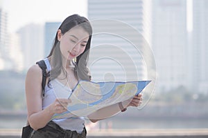 Beautiful asian solo tourist woman looking at the map searching for tourists sightseeing spot.