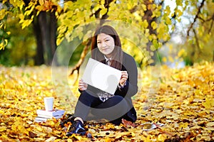 Beautiful asian student holding blank whiteboard in her hands