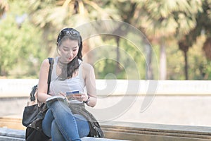 Beautiful asian tourist woman reading the travel guide book searching for for tourists sightseeing spot