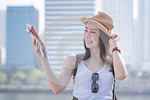 Beautiful asian tourist woman smiling and searching for tourists sightseeing spot