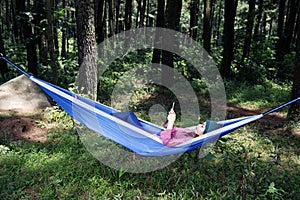 Beautiful asian traveler woman lying with smartphone in hammock