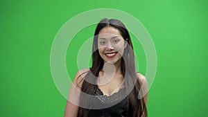 Beautiful Asian woman in black dress is smiling in green screen.