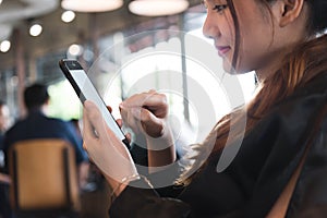 Beautiful asian woman in black dress working with smartphone in