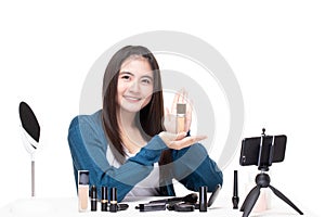 Beautiful asian woman blogger how to make up and use cosmetics. Happy asian girl vlogger recording video by smartphone share on