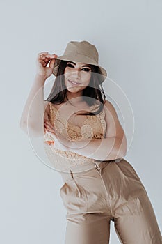 Beautiful asian woman brunette in beige fashionable clothes with hat