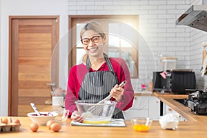 Beautiful asian woman cook the chocolate cake with happy feeling in the kitchen room