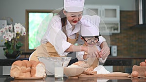 Beautiful Asian woman and cute little boy with eyeglasses prepare to cooking in kitchen at home together. Lifestyles and Family. H