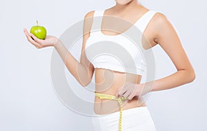 Beautiful asian woman diet and slim with measuring waist for weight and holding green apple fruit on white background