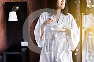 Beautiful asian woman drinking hot coffee at bedroom after wake up in the morning,Relax time,Happy and smiling,Healthy and lifesty