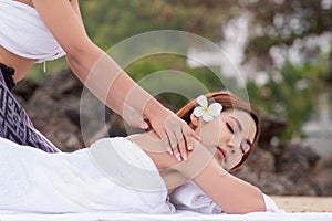 Beautiful asian woman enjoying spa massage therapy on the beach