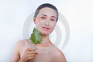 Beautiful asian woman face portrait with green leaf . Concept for skin care or organic cosmetics