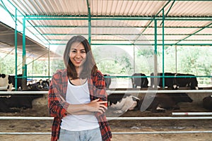 Beautiful asian woman or farmer with and cows in cowshed on dairy farm-Farming.