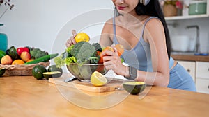 A beautiful Asian woman in gym clothes is preparing ingredients for her breakfast in the kitchen