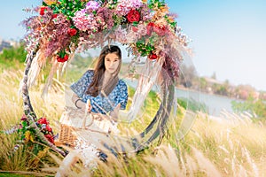 Beautiful Asian woman having relax time on a flower swing in nature field for nature hapiness lifestyle