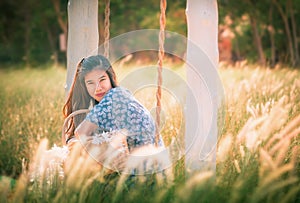 Beautiful Asian woman having relax time on a swing in nature field for nature hapiness lifestyle photo