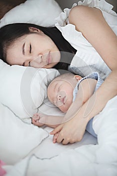 Beautiful asian woman and her son little baby sleeping together