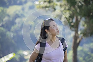 Beautiful asian woman hiking mountain. Female mountaineer having fun while climbing a mountain with a backpack