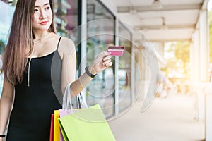 Beautiful asian woman holding credit card at the shopping mall.