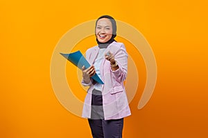 Beautiful asian woman holding folder and pointing ahead with pen with smiling face looking at camera