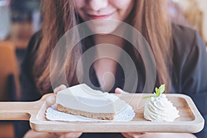 A beautiful Asian woman holding and looking at yogurt cheese pie with feeling happy and good lifestyle