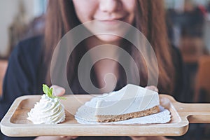 A beautiful Asian woman holding and looking at yogurt cheese pie with feeling happy and good lifestyle