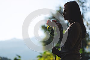 A beautiful asian woman holding red roses flower in the park