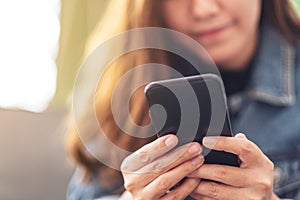 A beautiful asian woman holding , using and looking at smart phone