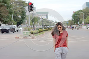 Beautiful Asian woman with long hair wearing sunglasses walking on street