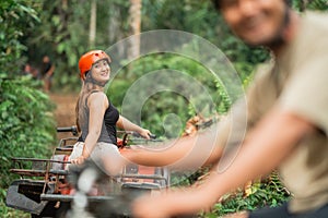 beautiful asian woman looking back to the camera while riding the atv