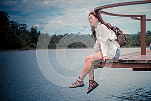 Beautiful asian woman Looking at river & mountains, the weather was great, feeling relaxed.