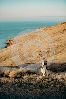 Beautiful asian woman  looking at view in field with sunset at New zealand countryside near the outskirts of Christchurch