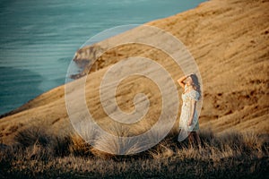 Beautiful asian woman  looking at view in field with sunset at New zealand countryside near the outskirts of Christchurch
