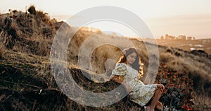 Beautiful asian woman  looking at view in field with sunset at New zealand countryside near the outskirts of Christchurch