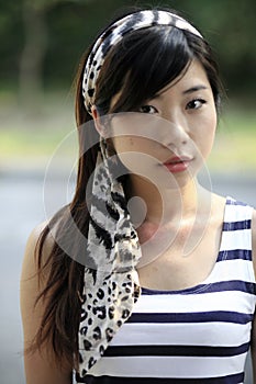Beautiful Asian woman looking at the viewer with a headscarf on her head