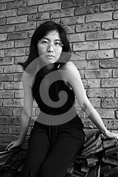 Beautiful Asian woman looking at the viewer sitting on wooden planks