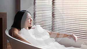 Beautiful Asian Woman Lying In Bathtub With Bubbles, Relaxing In Luxury Bathroom